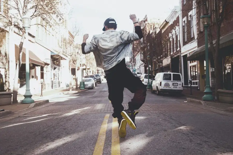 A kid running in the street and jumping