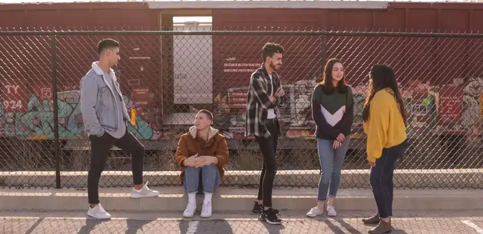 Teens standing in front of a train