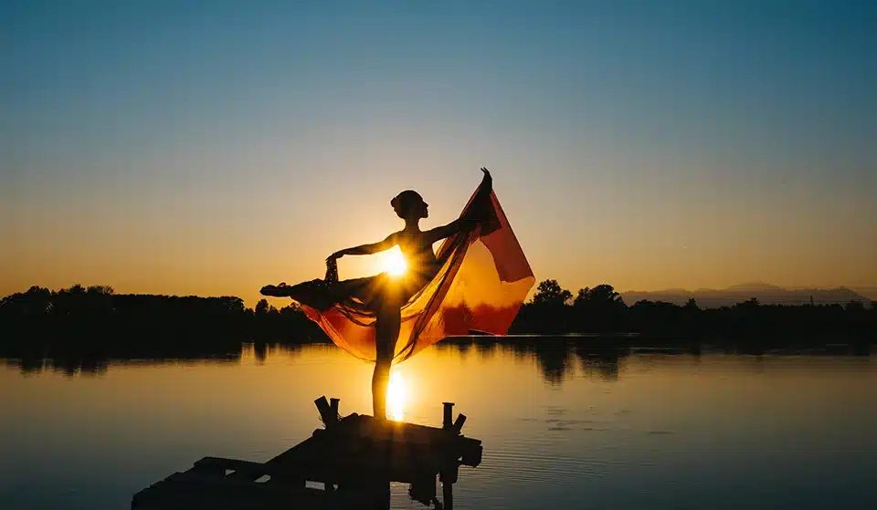 Lady standing in front of a sunset