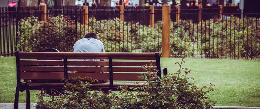 Kid sitting at bench in with their hands over their head