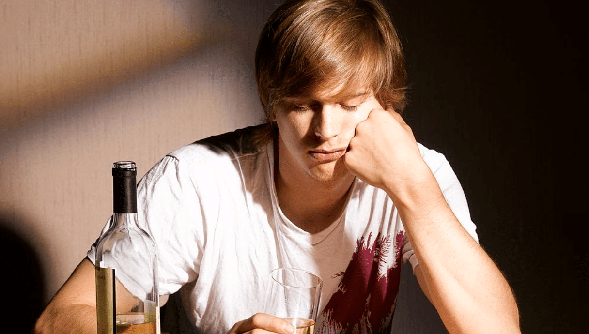 young boy staring at alcohol