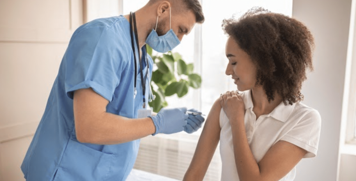 male nurse giving girl corona vaccine