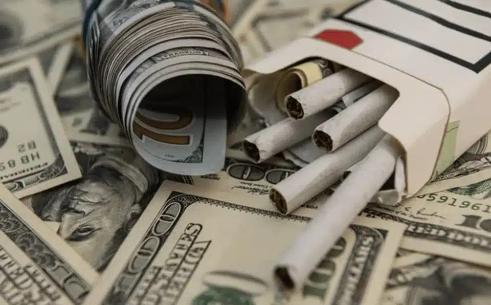 Bundle of Cash next to cigarettes