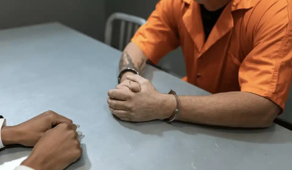 Picture of an inmate with his hands folded on a table