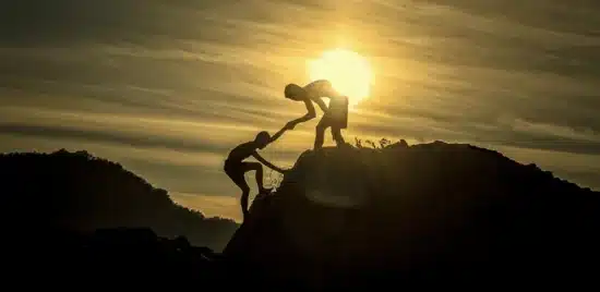 Person helping another one go up a hill