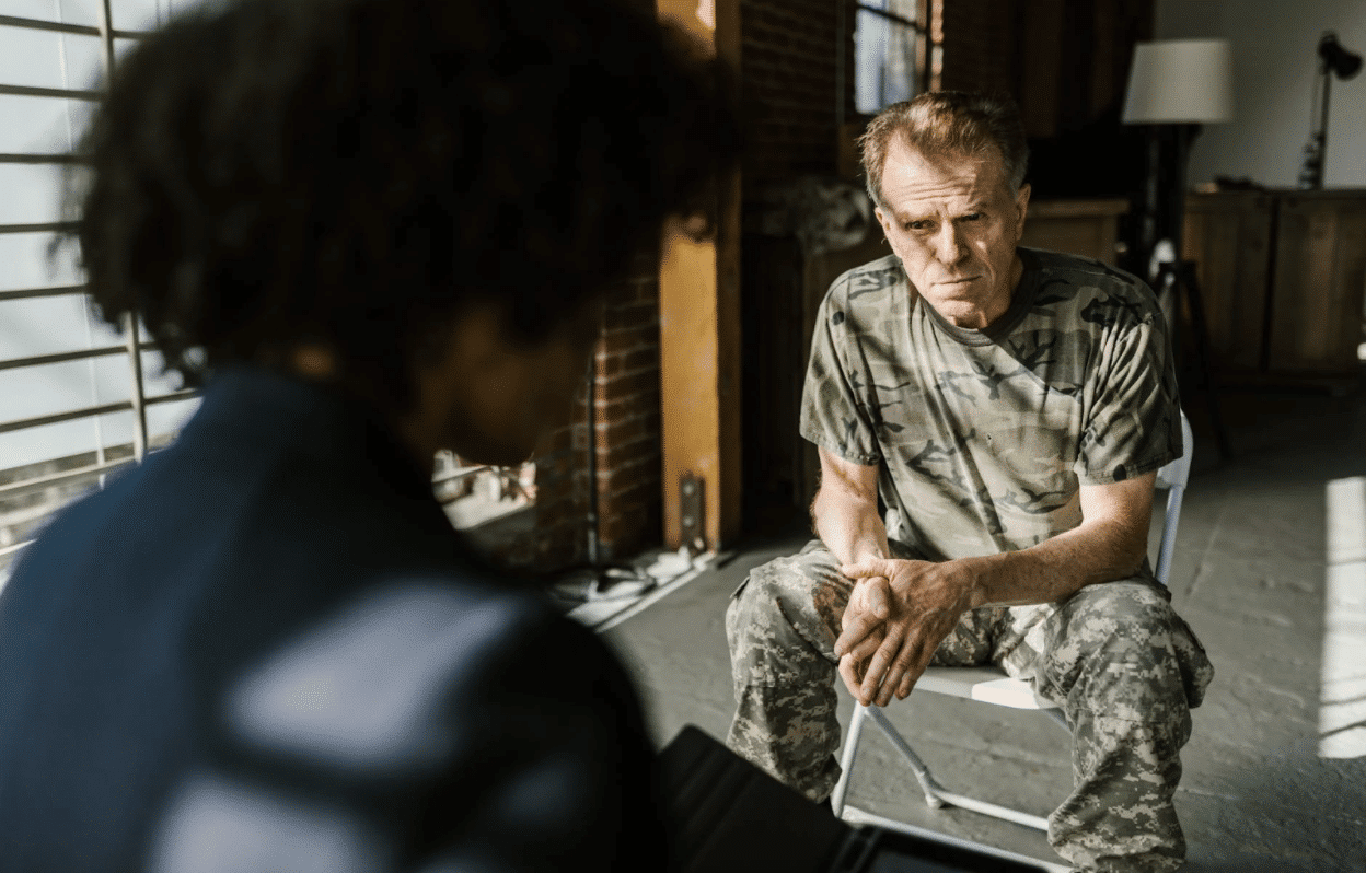 Man in army scrubs talking to a lady