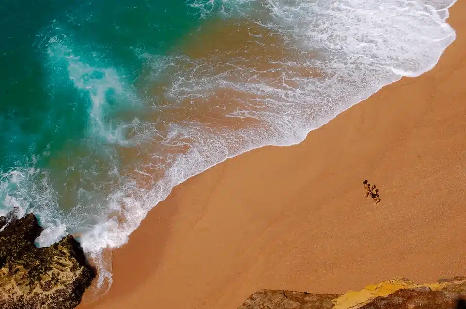 Drone photo of people walking on the beach near Opus Health