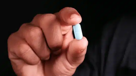 Hand holding up a pill