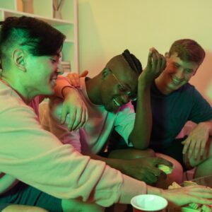 A photo of three students sitting at a table, doing substances.- Addiction in College: The Important Challenges and Solutions