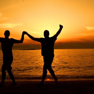 Celebrating Milestones in Addiction Recovery- A photo of two people celebrating their sobriety on the beach.