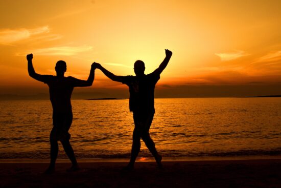 Celebrating Milestones in Addiction Recovery- A photo of two people celebrating their sobriety on the beach.