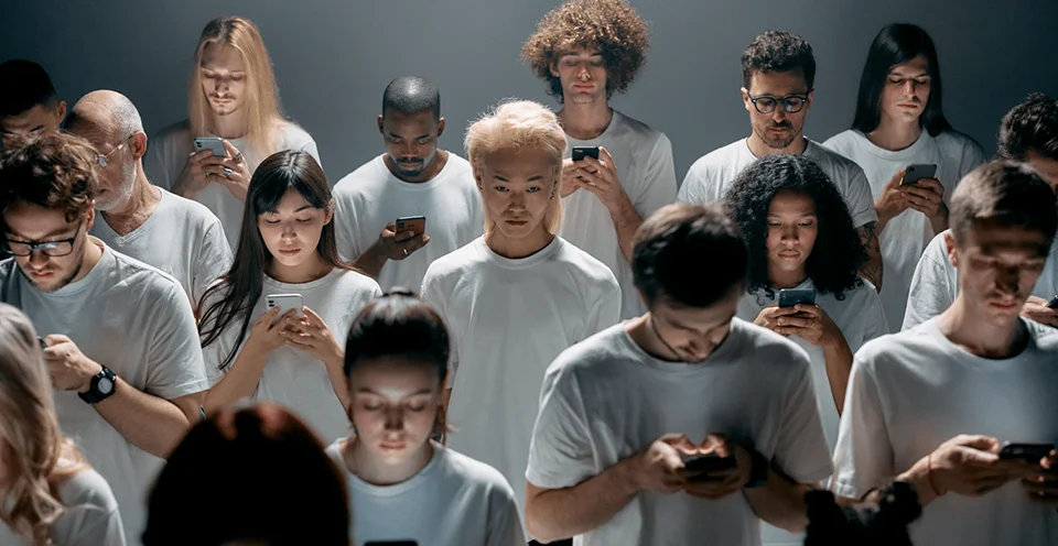 Person staring at the camera while everyone else stares at their phones