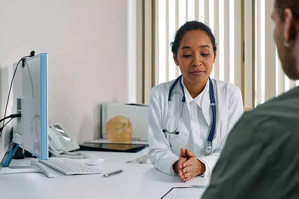 Person sitting with a doctor in an office