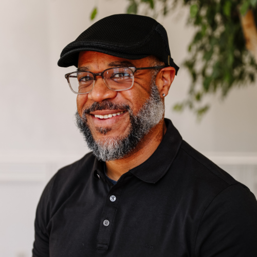 Our Team: David Oliver, smiling professional headshot with glasses and cap, showcasing team member profile.