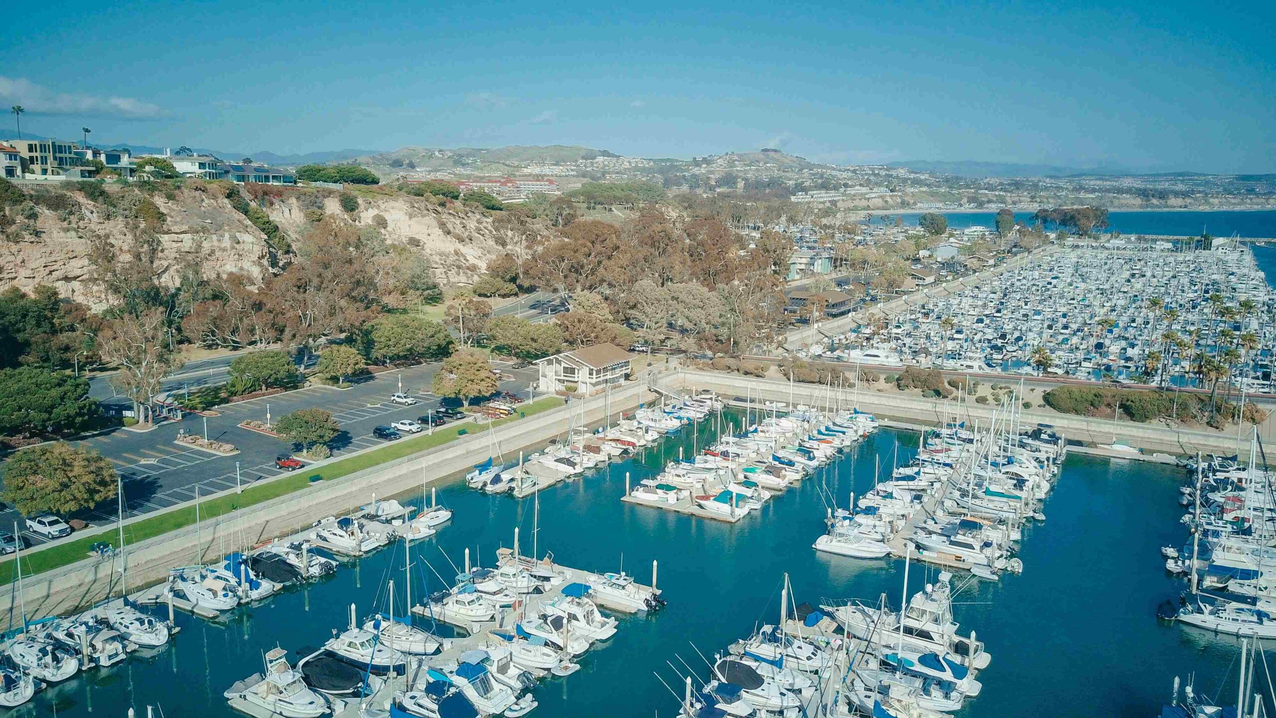 An aerial view of Dana Point harbor and surrounding coastal bluffs.
