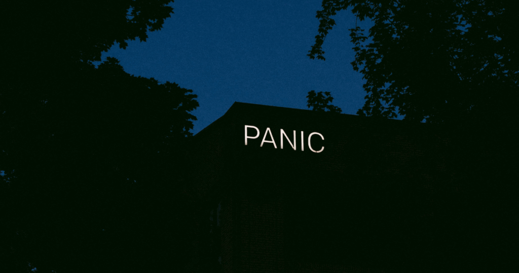 Panic sign on building, silhouetted by trees, representing Ativan withdrawal challenges and anxiety.