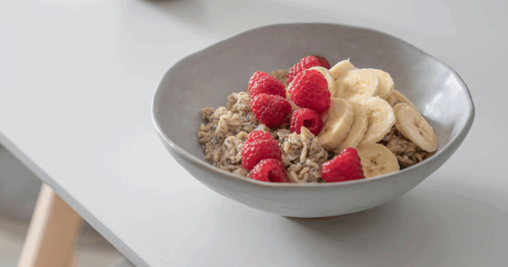 Healthy breakfast bowl with oatmeal, fresh raspberries, and sliced bananas. Support during Seroquel withdrawal.