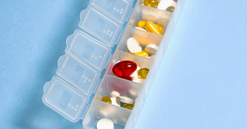 Pill organizer with various medications for anxiety management, including Xanax. Contains capsules and tablets of different colors.