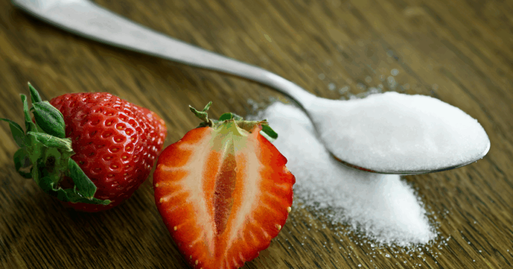 Sugar withdrawal: Fresh strawberries and a spoonful of sugar on a wooden table. Addressing sugar addiction and duration of withdrawal.