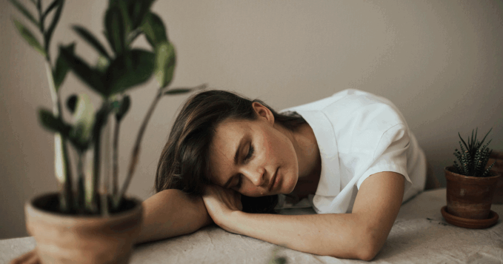 Woman experiencing Sertraline withdrawal symptoms, resting with plants. Mental health and medication side effects concept.