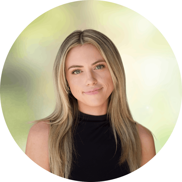 unnamed - Opus Health Portrait of a young woman with long blonde hair, wearing a black sleeveless top, smiling softly against a blurred green background.