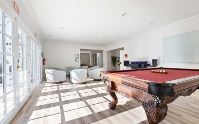 Bright room with pool table, white chairs and natural light. Ideal for Opus Treatment Center social space in Santa Ana.