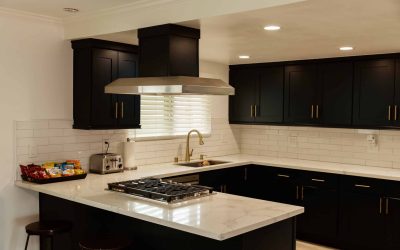 LP Facility Tour: Modern kitchen with black cabinets, stainless steel range hood, marble countertops, and subway tile backsplash.