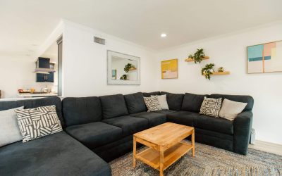 LP Facility Tour: Modern living room with a large sectional sofa, wooden coffee table, and stylish decor. Explore our facilities.