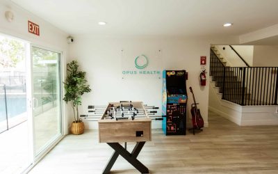LP Facility Tour: Recreation area with foosball table, arcade game, guitar and Opus Health logo.