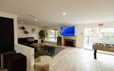 LP Facility Tour: Modern living room area with large screen TV, fireplace, foosball table, and comfortable seating.