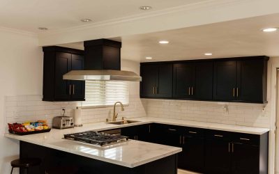 LP Facilities Tour: Modern kitchen with black cabinets, white marble countertops, stainless steel appliances, and subway tile backsplash.