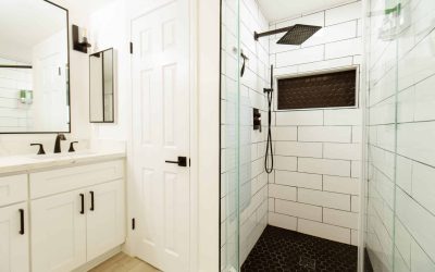 CariHouse bathroom featuring a modern shower with black fixtures and hexagon tile, and a vanity with a white countertop.