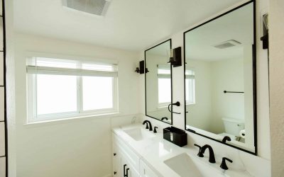 Modern bathroom interior with double vanity, white marble countertop, black fixtures, and framed mirrors. Luxury bathroom design.