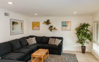 Living room interior featuring a dark blue sectional, wooden coffee table, and modern decor. Interior design showcasing home facilities.