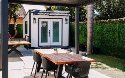 Outdoor office shed with a patio table and chairs, creating a modern backyard workspace and entertainment area.